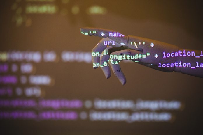 robotic hand reaching for something with program code projected on it