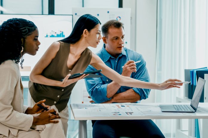 Diverse finance team business meeting discussing investment strategy and financial report presentation on laptop at modern office. Marketing strategy analysis, financial consultant concept.