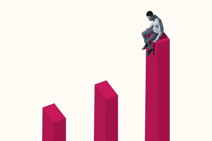 Young man sitting on tall pink bar graph